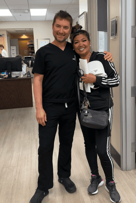 Dr. Alexander Antipov with a smiling dental implant patient