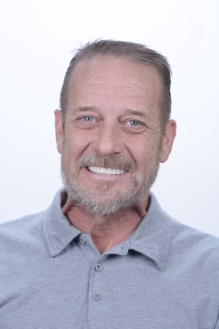 Male patient smiling after full-arch restoration