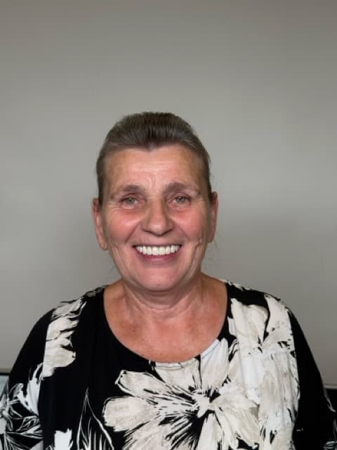 Female patient smiling after full-arch dental implant restoration